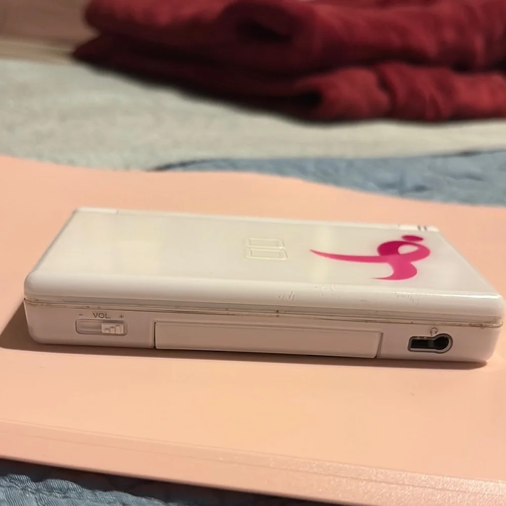 White Handheld Gaming Console with Pink Ribbon